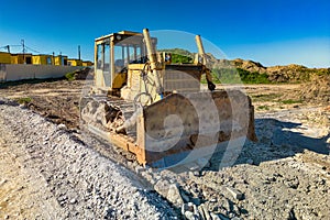 Bulldozer during the construction of a new road. Top view of a powerful working bulldozer. Earthmoving equipment for road works,