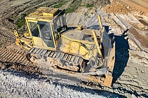 Bulldozer during the construction of a new road. Top view of a powerful working bulldozer. Earthmoving equipment for road works,