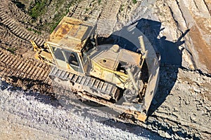 Bulldozer during the construction of a new road. Top view of a powerful working bulldozer. Earthmoving equipment for road works,