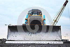 Bulldozer at construction site. Heavy equipment for digging, demolition, construction and ground works. Dozer for earth-moving,