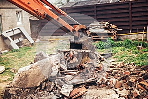 bulldozer on demolition site working on building and loading bricks and concrete into dumper trucks