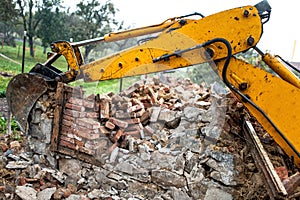 Bulldozer on demolition site working on an old building and load