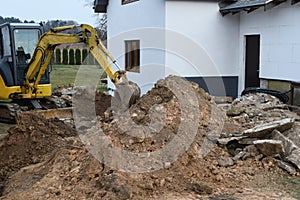 Bulldozer digs at construction site and large pile of sand material.