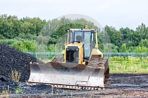 Bulldozer dredges rubble on road construction