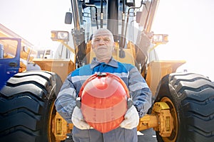 Bulldozer driver coal mine in uniform with helmet and headphones looking to side. Concept man industrial portrait photo