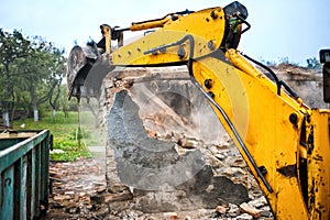 Bulldozer and excavator demolishing concrete walls photo
