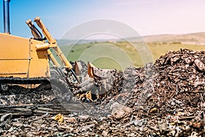 bulldozer levelling garbage grounds. Heavy duty machinery working on construction site