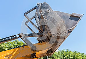 Bulldozer lifting bucket. Excavator bucket against sky