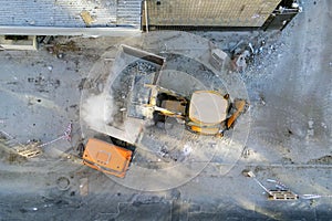 Bulldozer loader uploading waste and debris into dump truck at construction site. building dismantling and construction