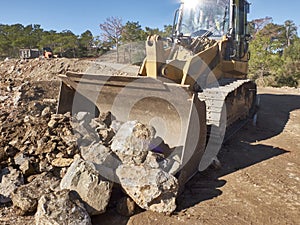 Bulldozer is moving boulders during road construction works