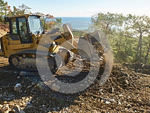 Bulldozer is moving soil during road construction works