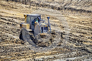 Bulldozer push dirt in excavation pit