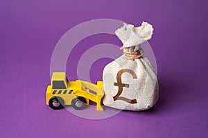 A bulldozer pushes a british pound sterling money bag. Ineffective use of funds.