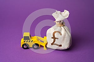 A bulldozer pushes a british pound sterling money bag. Ineffective use of funds. photo