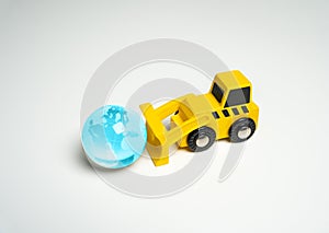 Bulldozer pushes glass planet earth globe. Human impact on the environment, prompting reflection on ecological concerns and the