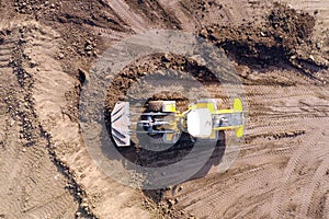 Bulldozer pushing large amount of fresh soil, Aerial shot.