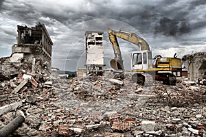 Bulldozer removes the debris from demolition of derelict buildings