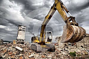 Bulldozer removes the debris from demolition of derelict buildings