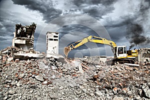 Bulldozer removes the debris from demolition of derelict buildings