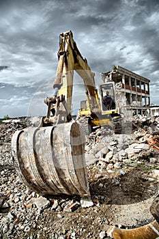 Bulldozer removes the debris from demolition of derelict buildings