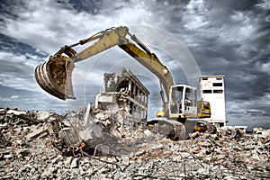 Bulldozer removes the debris from demolition of derelict buildings