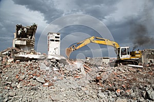 Bulldozer removes the debris from demolition of derelict buildings