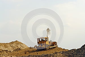 Bulldozer on sand heap