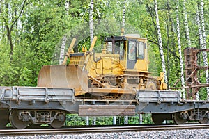 Bulldozer stands on the railway transporter.