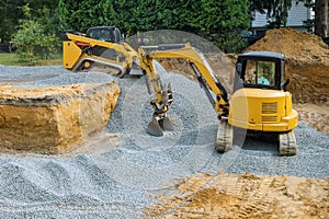 A bulldozer on wheels backfill of foundation work on the construction site to the building under construction