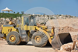 Bulldozer on wheels shovels large stones