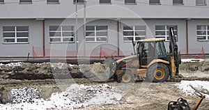 The bulldozer works on a construction site with sand, side view. New Big Tractor, a bulldozer on wheels on a sandy road