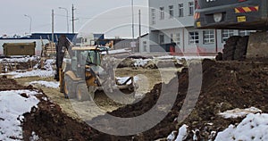 The bulldozer works on a construction site with sand, side view. New Big Tractor, a bulldozer on wheels on a sandy road