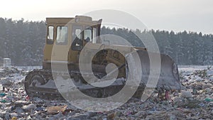 Bulldozer works at garbage dump in winter, Russia