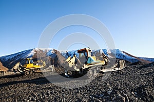 Bulldozers remove the top layer of mountain soil. Extraction of minerals in the highlands.