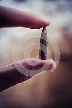 Bullet After Being Shot, Holding in Hand, Sands and Snow in the Background