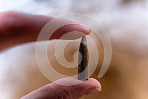 Bullet After Being Shot, Holding in Hand, Sands and Snow in the Background - With Ballistic Marks