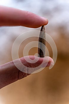Bullet After Being Shot, Holding in Hand, Sands and Snow in the Background - With Ballistic Marks