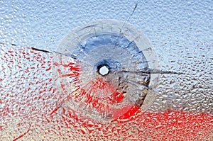 Bullet hole in broken glass and blood