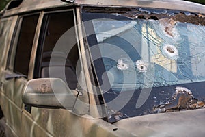 Bullet hole on a car windshield. Car window after a raid has a bullet hole. Broken glass. Bullet holes in a front windshield.