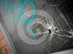 Bullet hole and cracks in a reinforced window