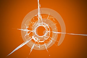 Bullet hole in glass close up on orange background