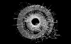 Bullet hole in glass isolated on black photo