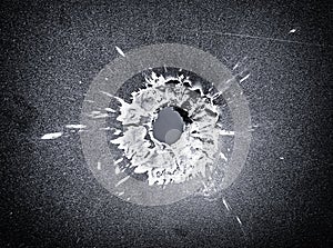 Bullet hole in the metal plate, black and white photo