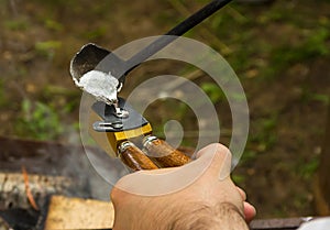 Bullet making round projectile for historical weapons muskets liquid metal is poured is formed in hand form against the background