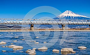 Bullet train passing Mount Fuji and the Fujikawa bridge, Shizuoka, Japan