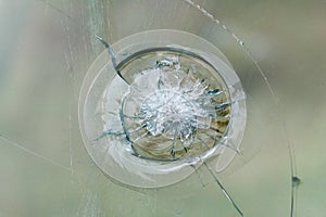 Firearms bullethole on bulletproof glass, cracks background photo