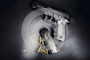 Bullets and handcuffs. Close-up of 9mm pistol. Gun and weapon with bullets amunition on black backround. Top view.
