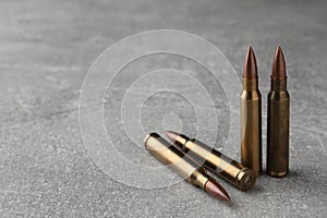 Bullets on light grey table, closeup. Space for text