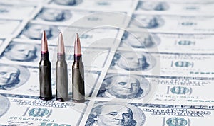Bullets on US Dollar bills as symbol of bloody business, military conflicts and murders. Free copy space for text or design photo