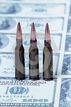 Bullets on US Dollar bills as symbol of bloody business, military conflicts and murders. Vertical image